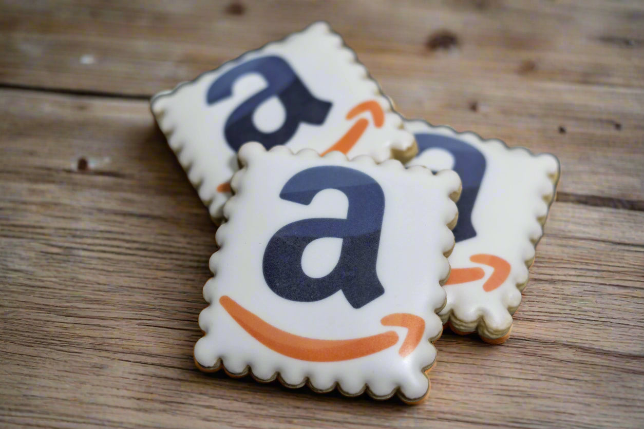 Square scalloped cookie with Amazon logo and smile printed on white icing.