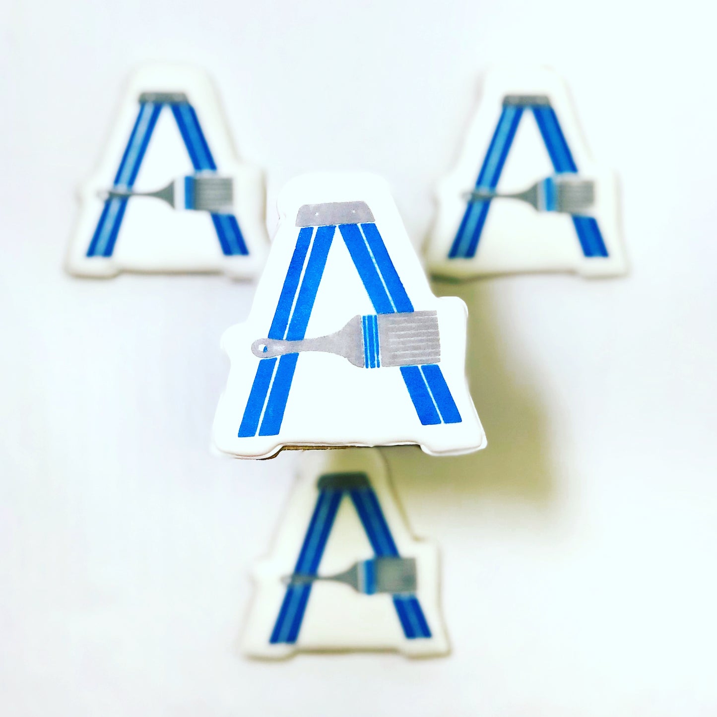 Custom shaped sugar cookie with Allegiant Painting LLC logo printed on white icing.