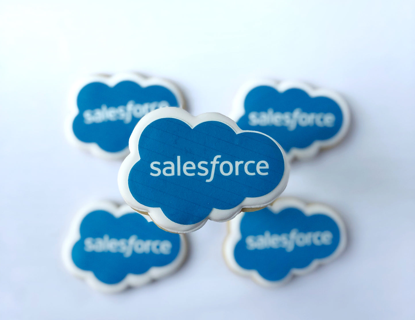 Custom shaped sugar cookie with SalesForce logo printed in blue on white background.