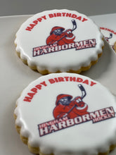 Load image into Gallery viewer, Round scalloped cookie with Happy Birthday and Hingham Harbormen Hockey logo printed on white icing.