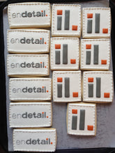 Load image into Gallery viewer, Rectangle and Square sugar cookies with Endetail logo in 2 designs in gray and orange icing on white icing background.