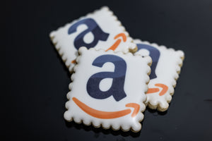 Square scalloped cookie with Amazon logo and smile printed on white icing.